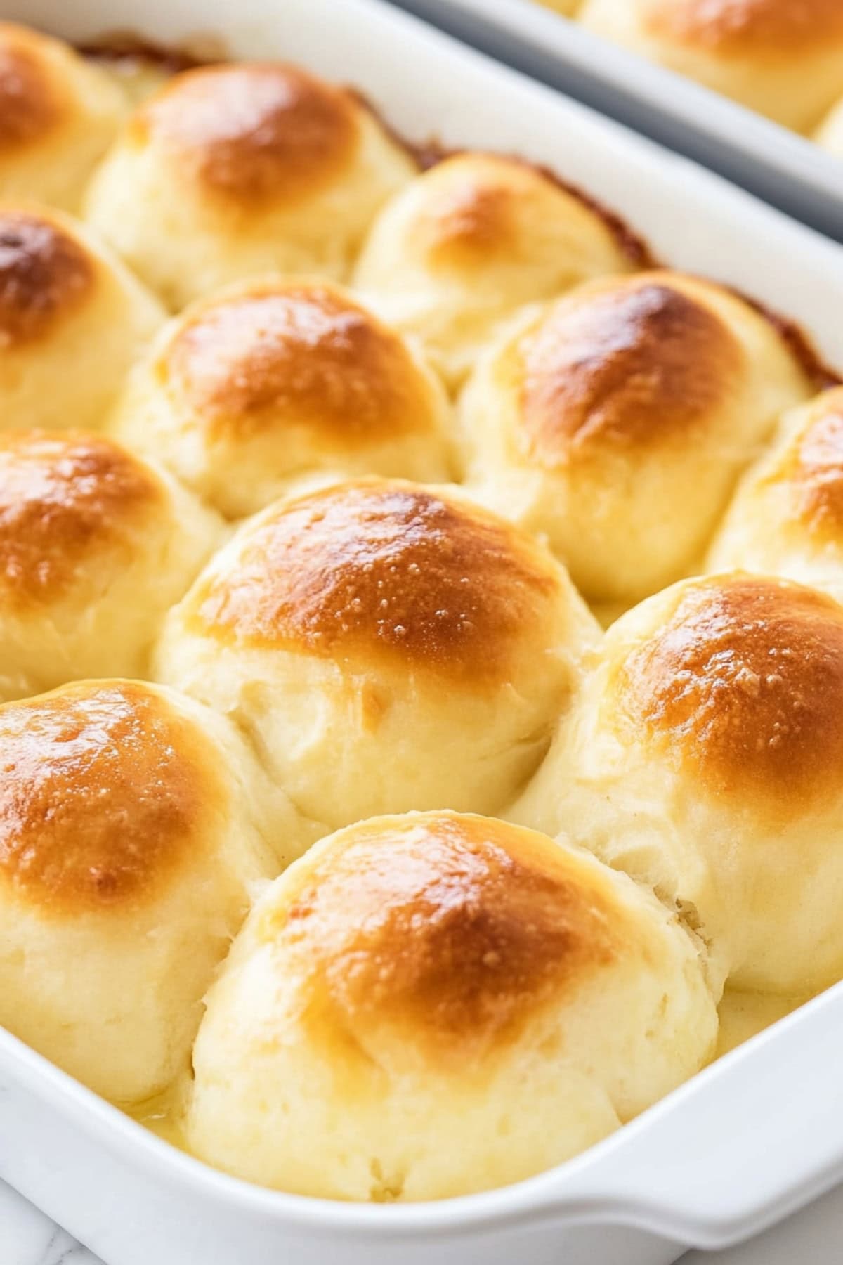 Golden-brown potato rolls in a baking dish.