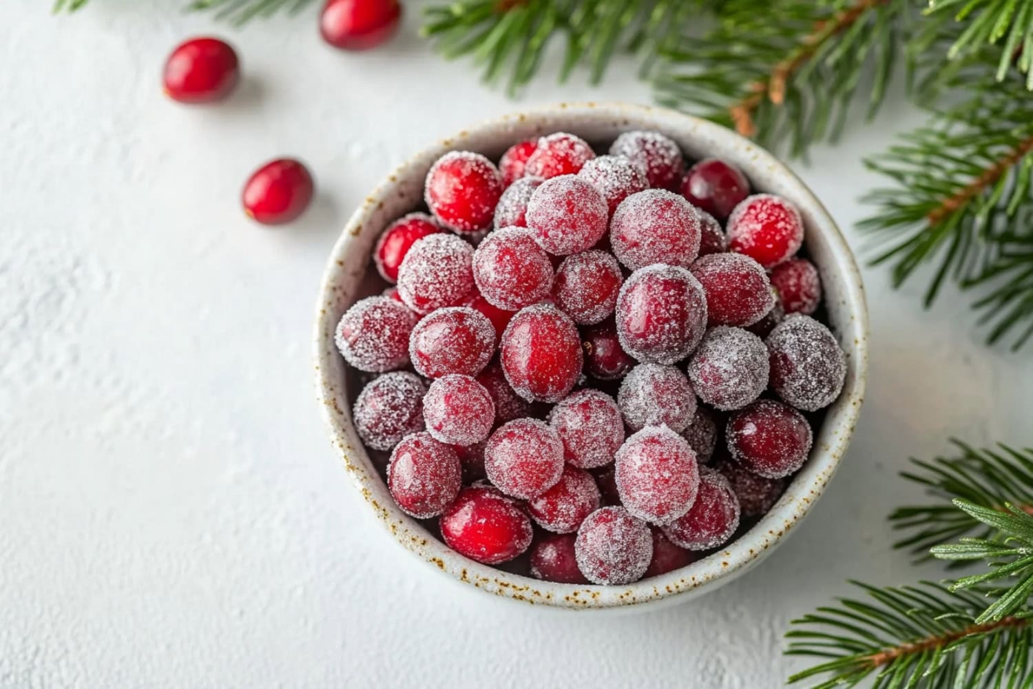 Sugared cranberries in a bowl, top view.