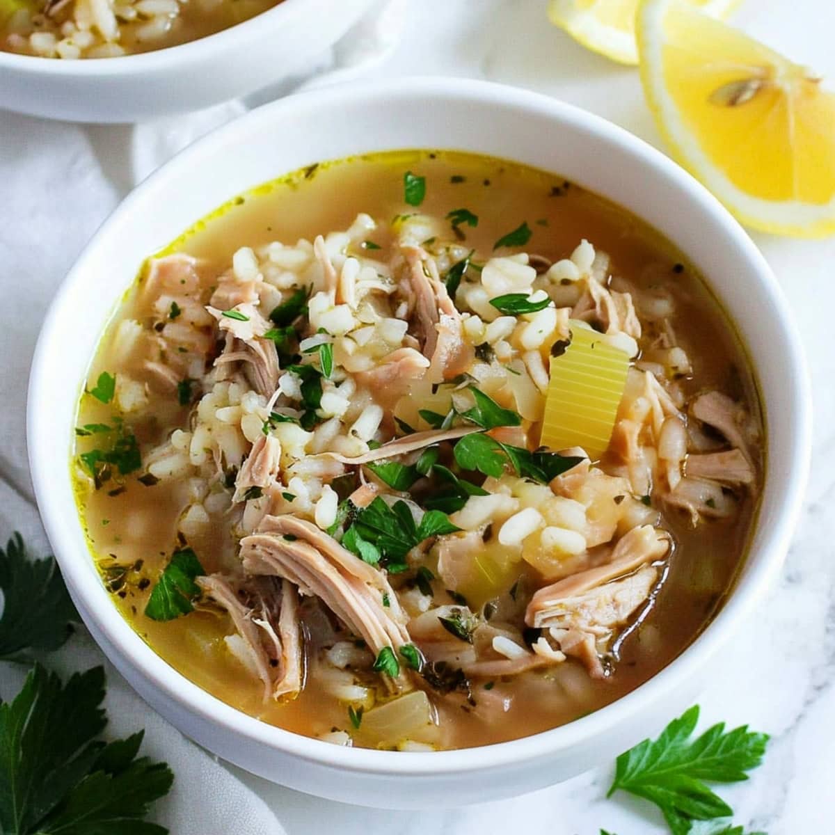 A comforting bowl of turkey and rice soup, garnished with fresh parsley.