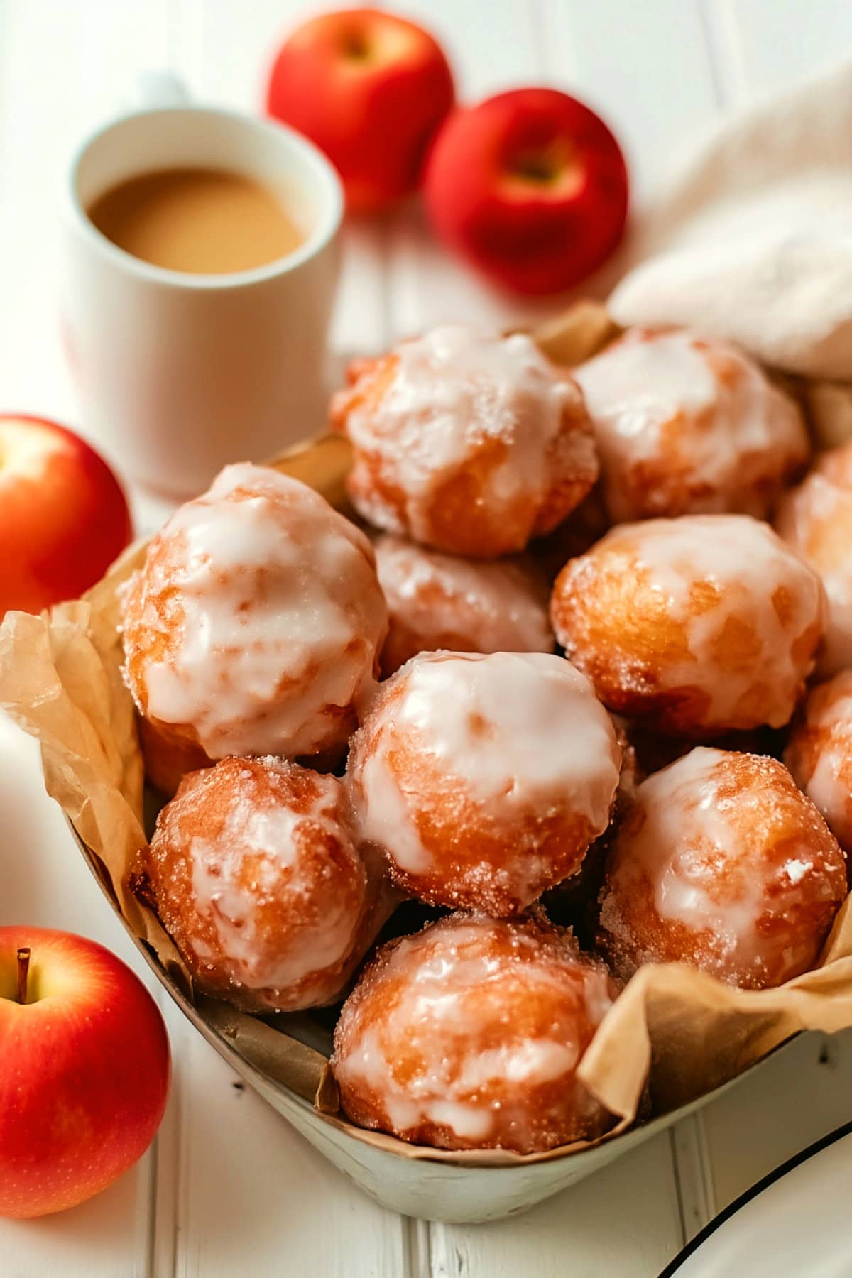 Apple Fritter Bites in a rectangular dish, with a cup of coffee on the side.