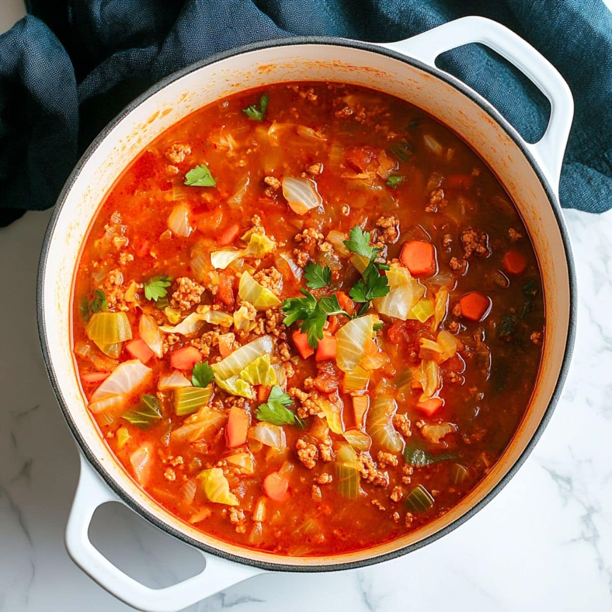 Cabbage roll soup with ground beef and chopped vegetables in tomato based soup cooked in a pot.