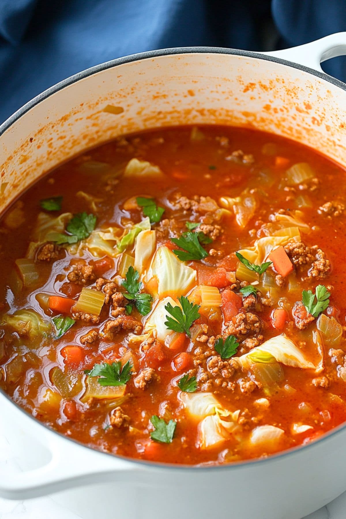 Cabbage roll soup with ground beef cooked in tomato base soup in a Dutch oven pot. 