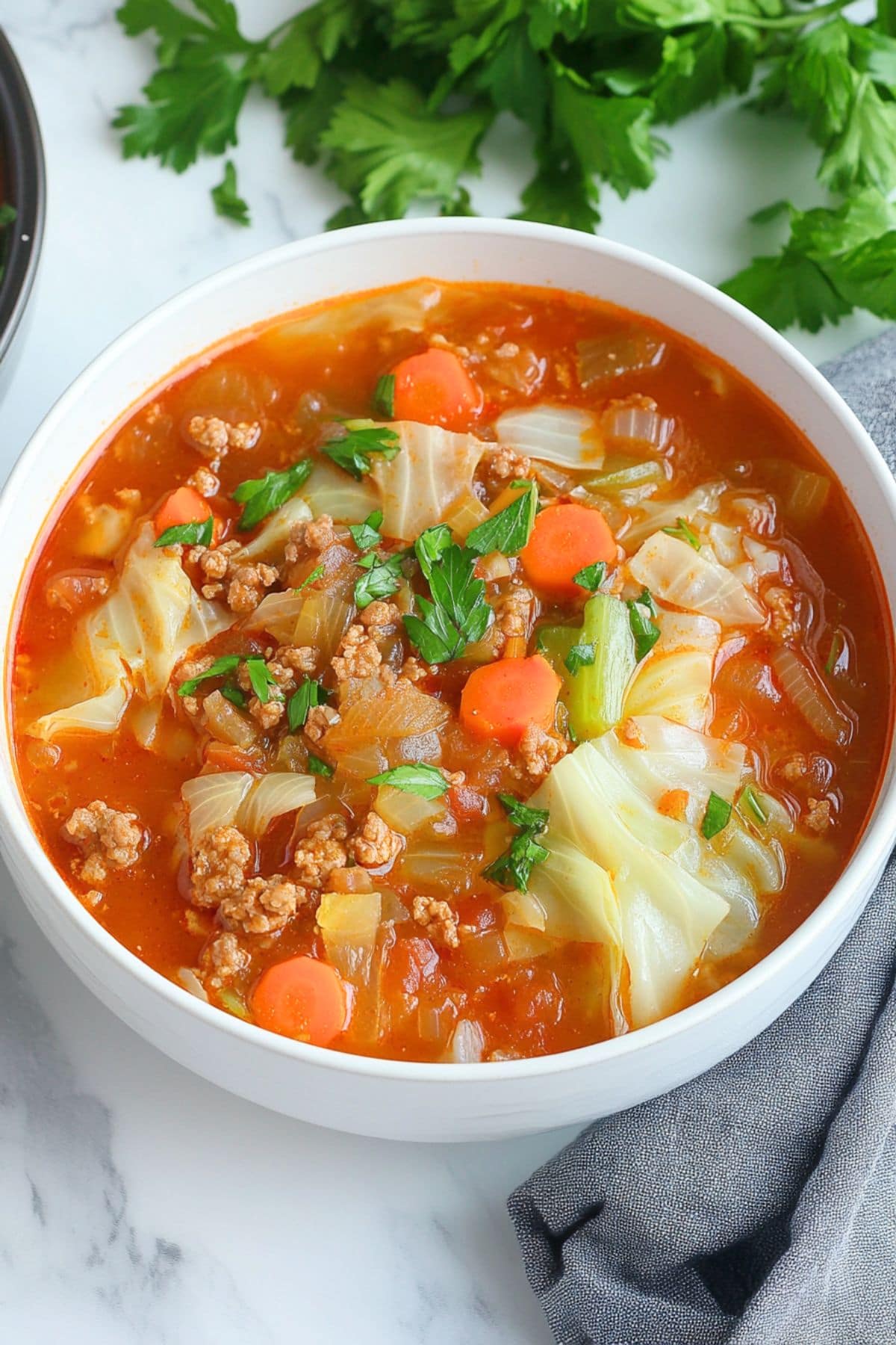 Serving of cabbage roll soup in a white bowl. 