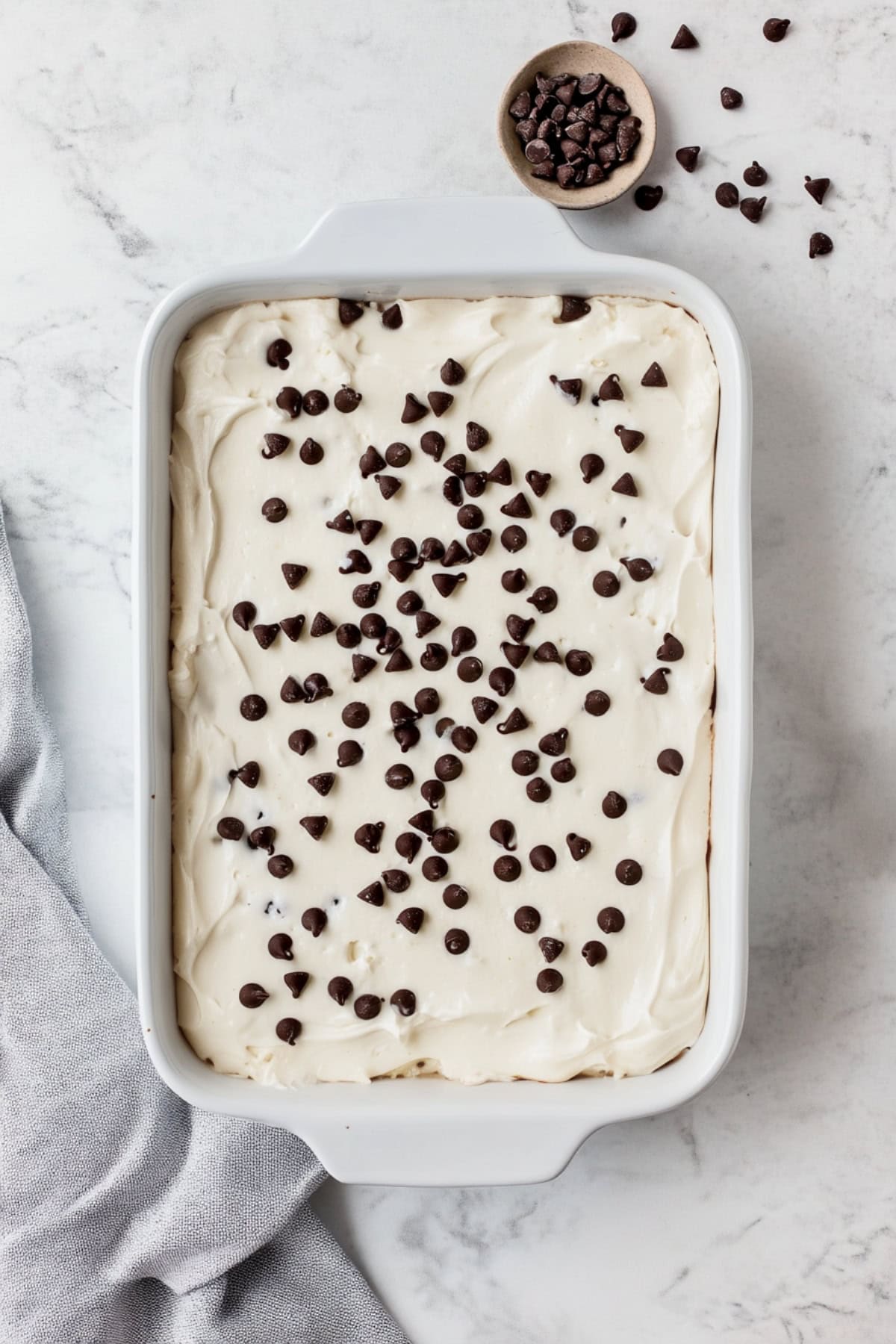 An overhead view of cannoli poke cake with mini chocolate chips.