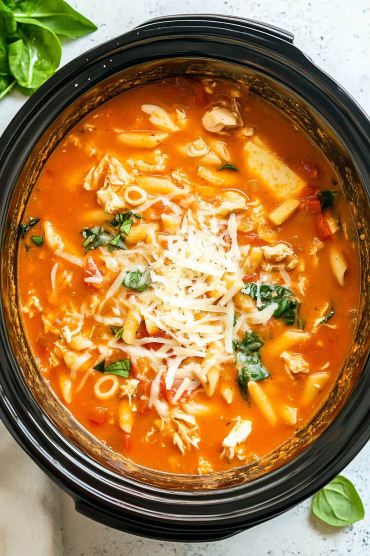 Tomato based soup with shredded chicken, cheese and chopped baby spinach cooked in a crockpot.