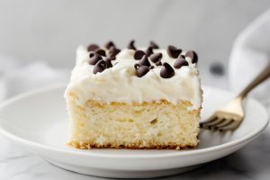 Decadent homemade cannoli poke cake with mini-chocolate chip toppings.