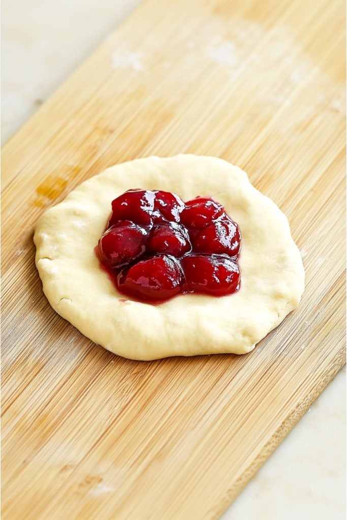 Biscuit dough with cherry pie filling in the middle