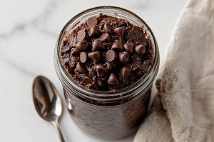 Close-up of creamy edible brownie batter featuring a smooth texture and scattered chocolate chips.