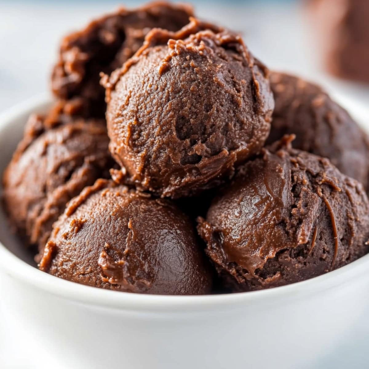 A bowl filled with scoops of delicious edible brownie batter, close up