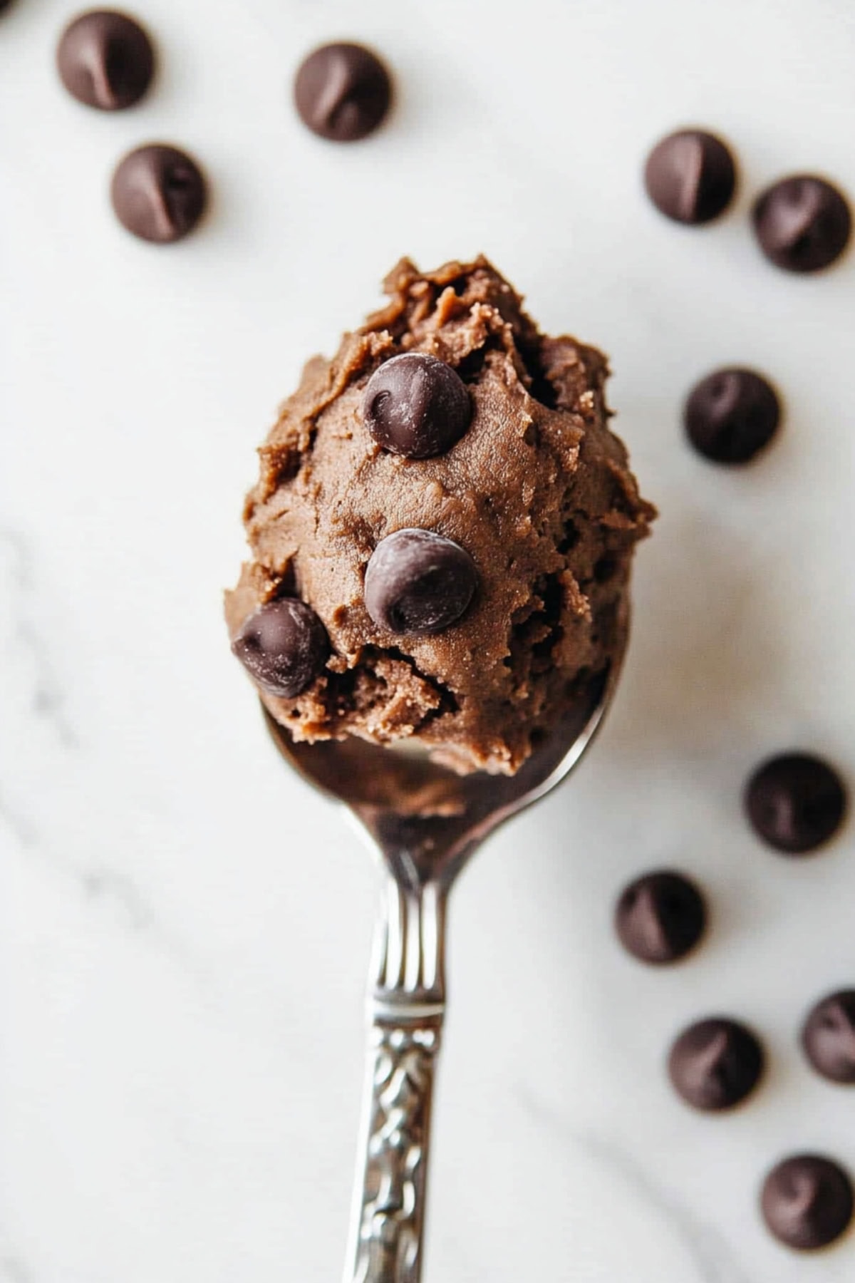 A heaping spoonful of decadent edible brownie batter with chocolate chips, top view