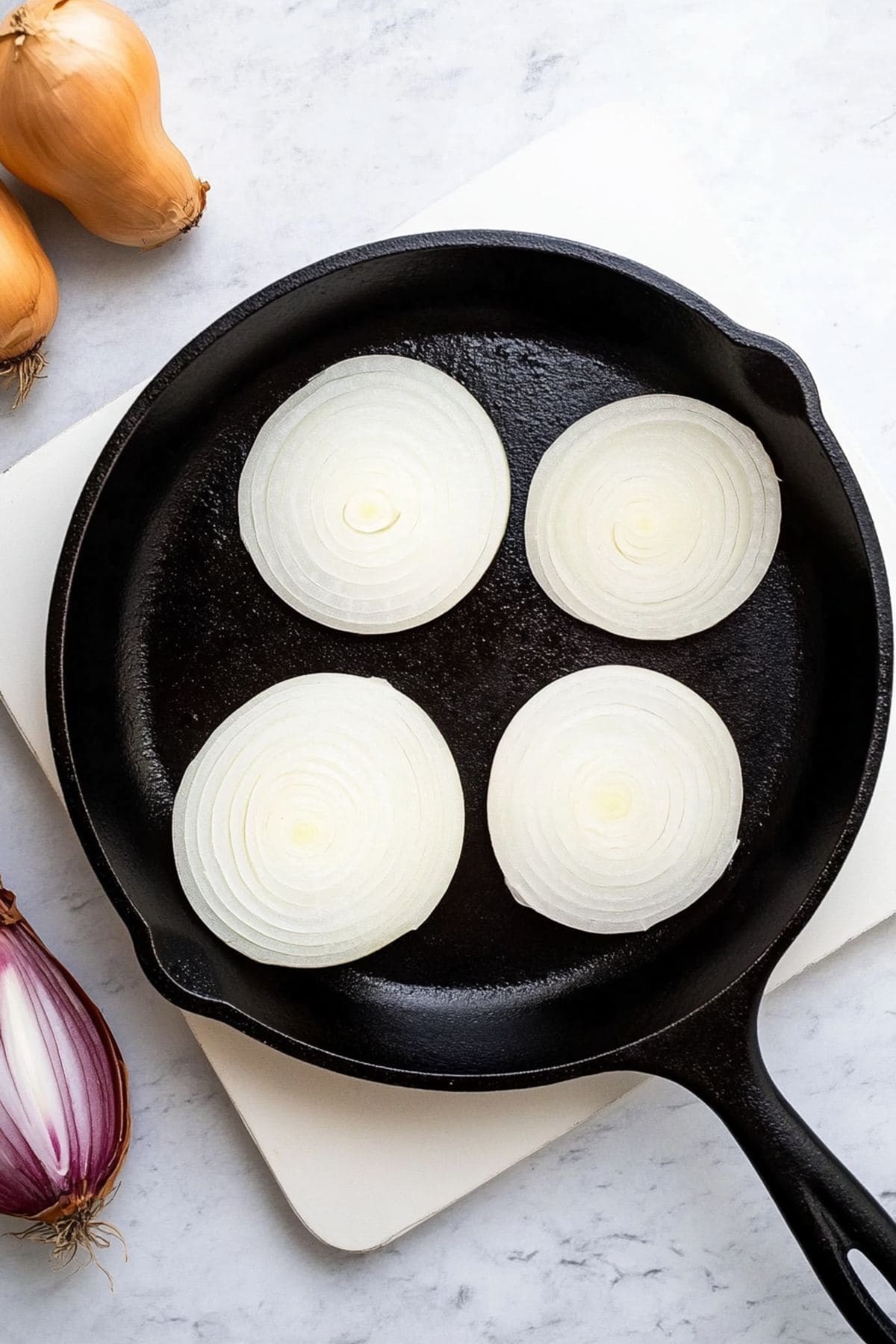 Onion round slices in a skillet pan.