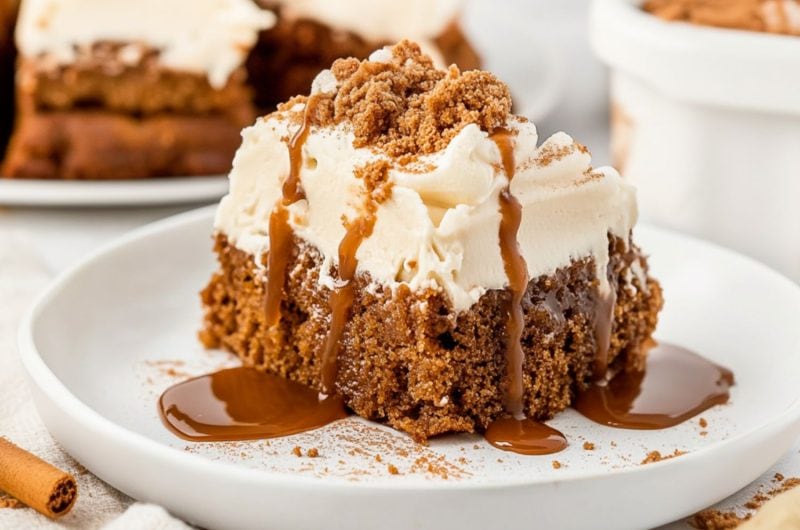 Gingerbread poke cake square slice drizzled with caramel sauce served in a white plate.