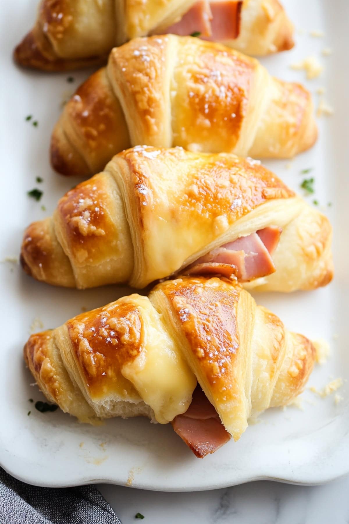 Ham and cheese crescent rolls lined on a plate, top view