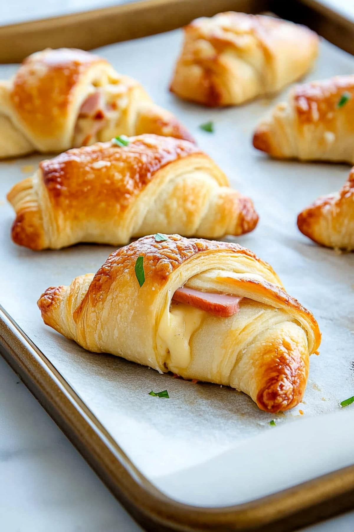 Ham and cheese crescent rolls on a baking tray