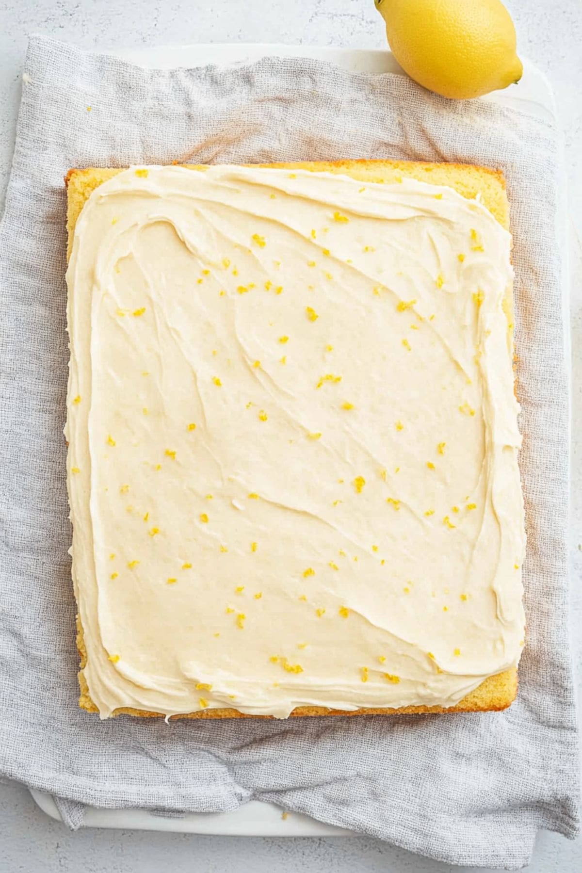 Lemon sheet cake with spread of cream cheese on top. 