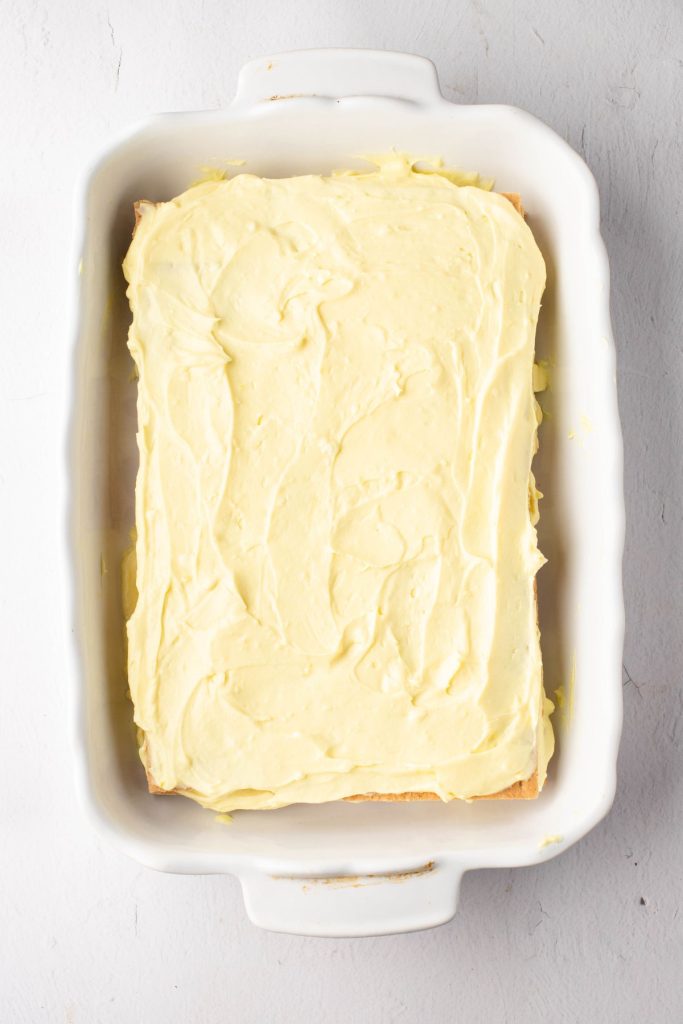 Layered graham crackers covered with pudding in a rectangular white baking dish.