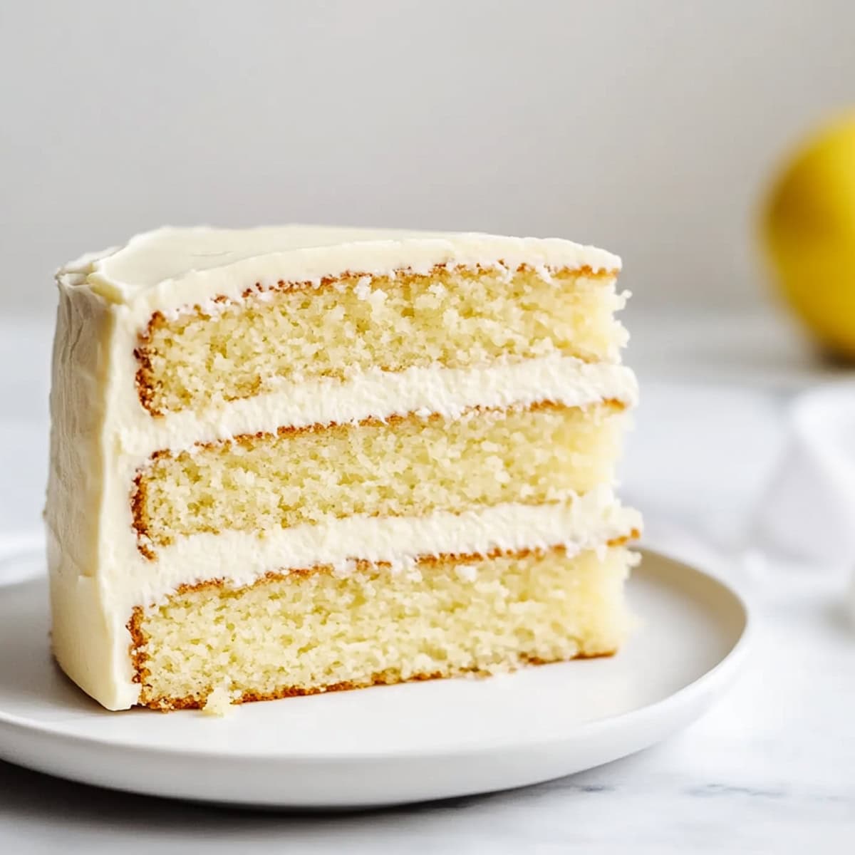 A slice of lemon velvet cake with moist, layers and a creamy lemon frosting