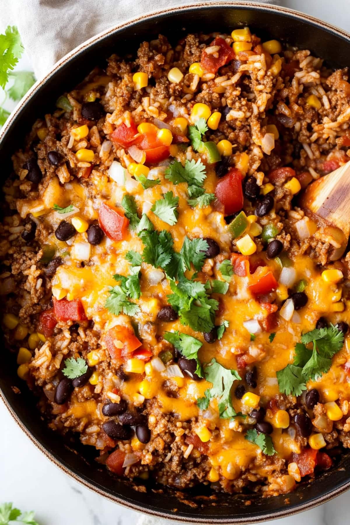 A close-up shot of beef and rice skillet with corn, bell peppers and tomatoes.