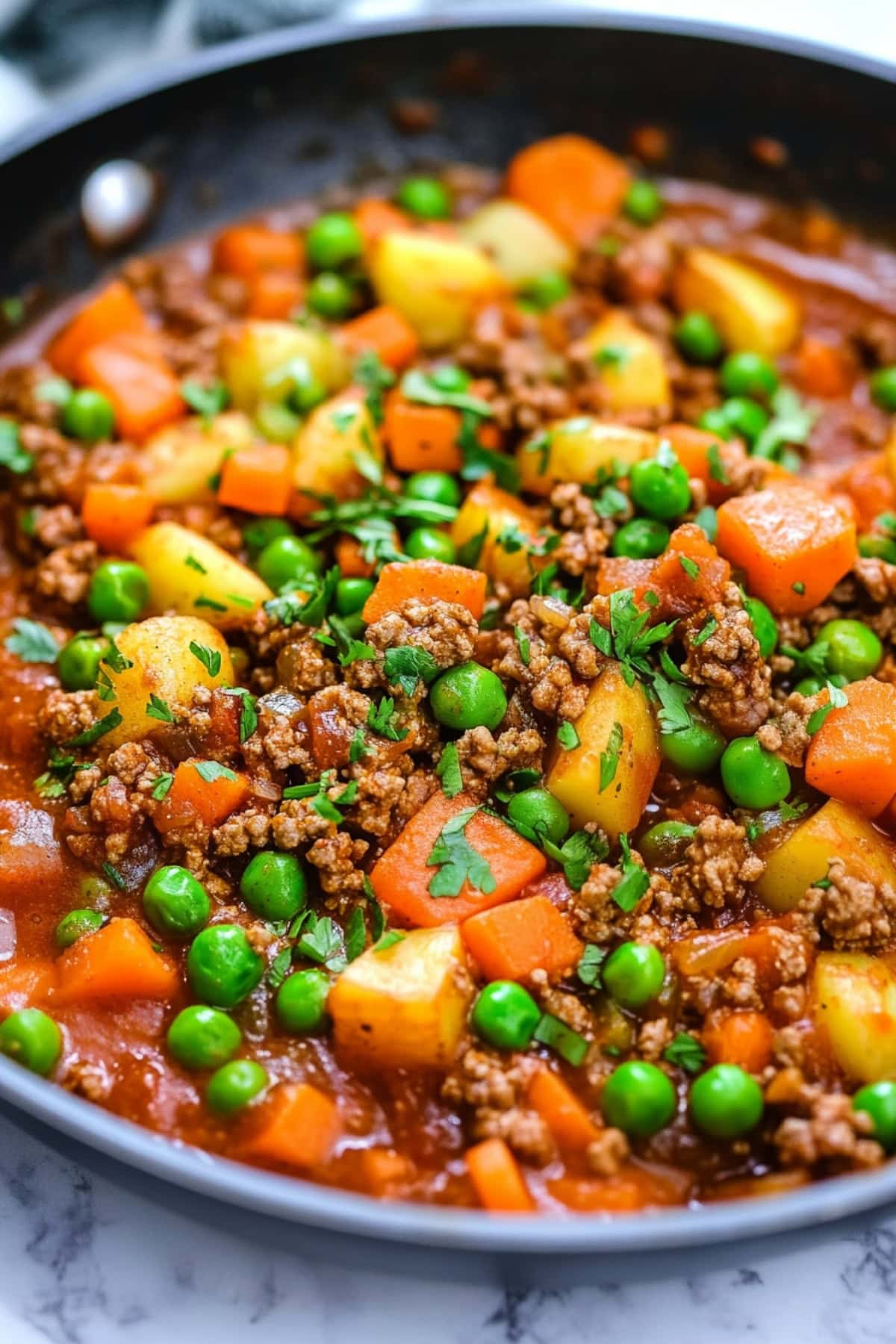 Mexican picadillo with veggies and ground beef cooked in a pan.