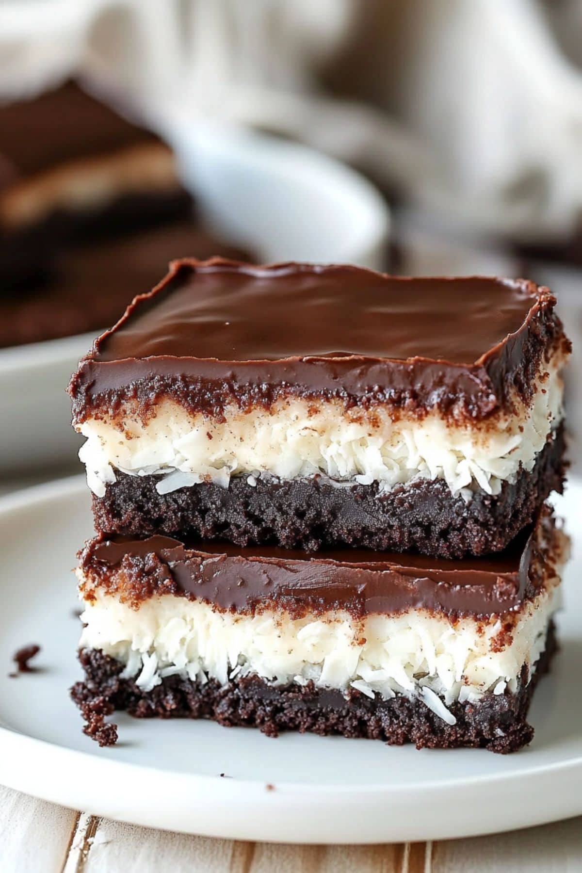 Two slices of mounds brownies stacked on top of each other served on a plate.