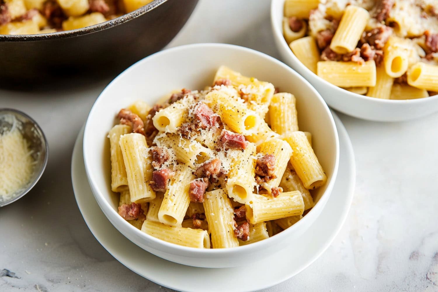 Bowls of rigatoni pasta alla gricia with pork guanciale, black pepper and grated cheese.