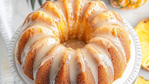 Pound cake in a cake tray drizzled with white glaze.