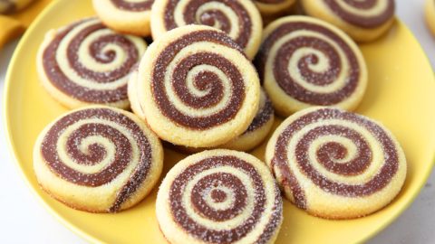 Bunch of pinwheel cookies served in a yellow plate.