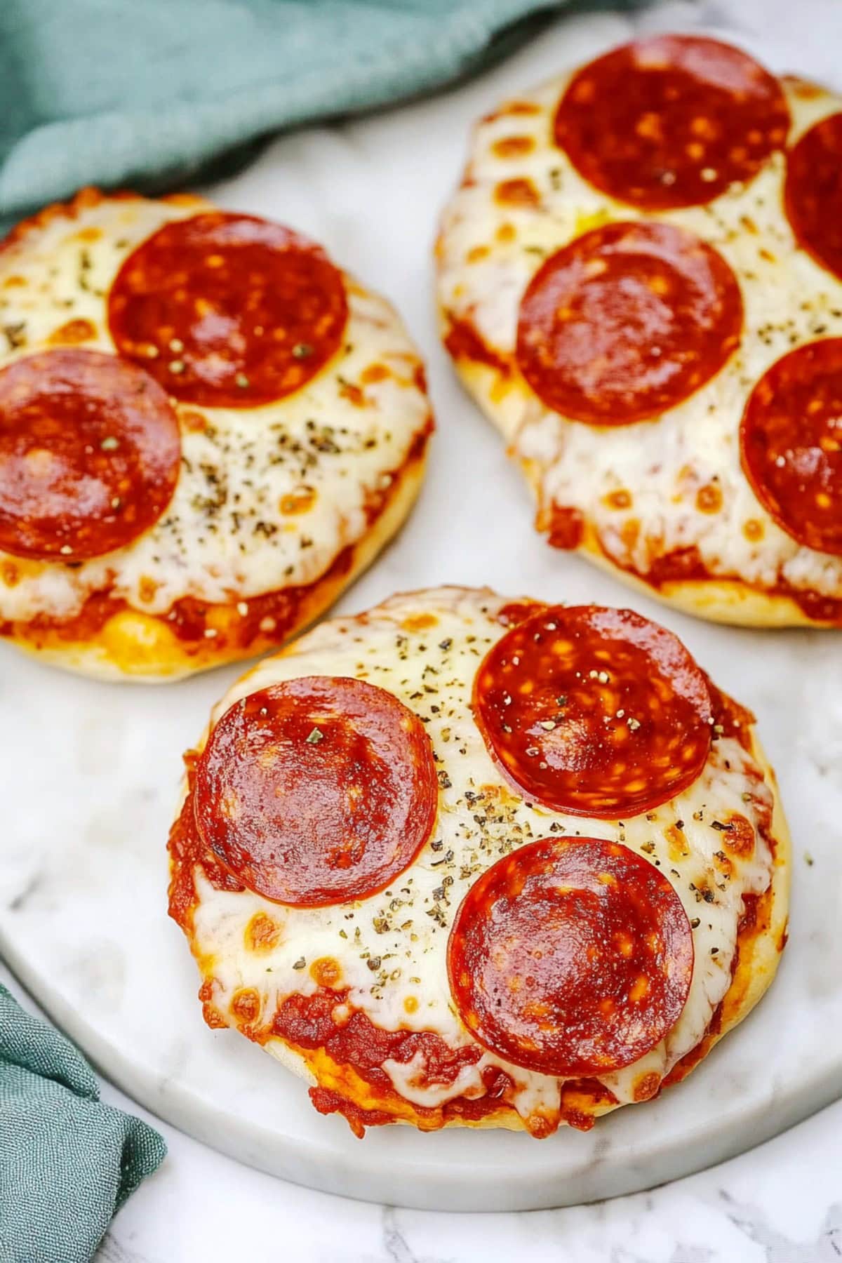 Freshly baked pizza bagels with melted cheese and pepperonis.