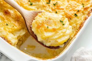 Golden-brown potatoes au gratin with a hint of chives on top, freshly baked and served hot from the oven.