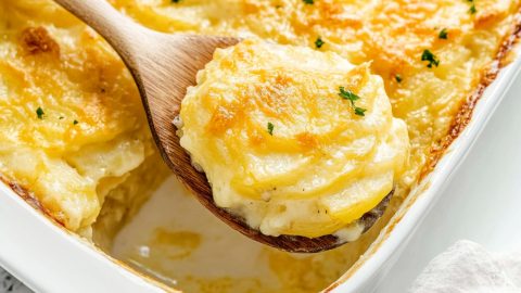 Golden-brown potatoes au gratin with a hint of chives on top, freshly baked and served hot from the oven.