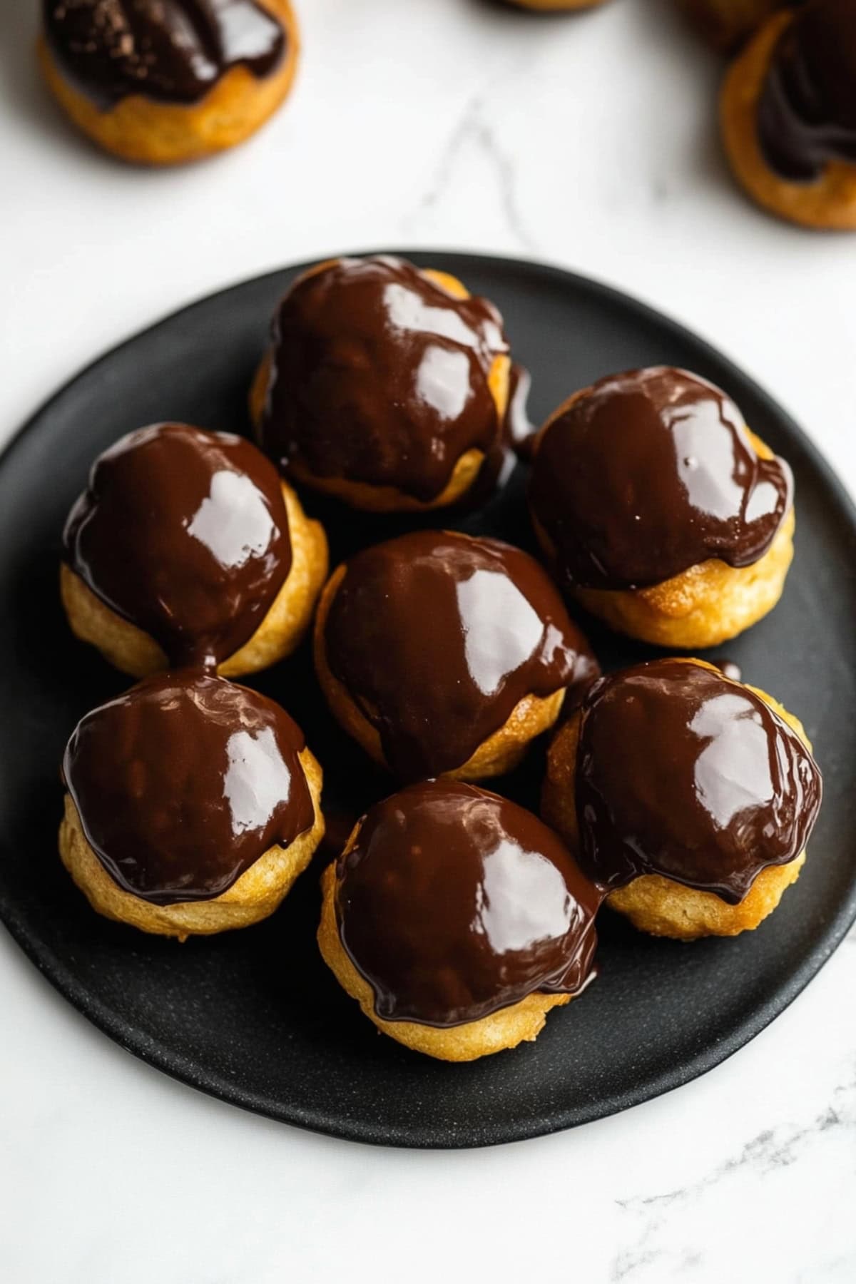 Profiteroles on A Black Plate, Top View