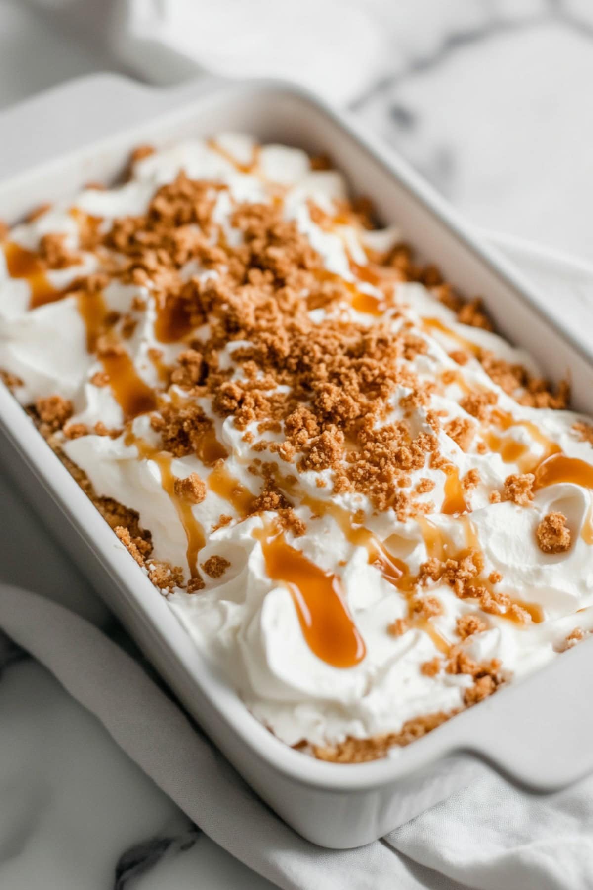 Pumpkin Poke Cake Topped with Whipped Cream and Caramel