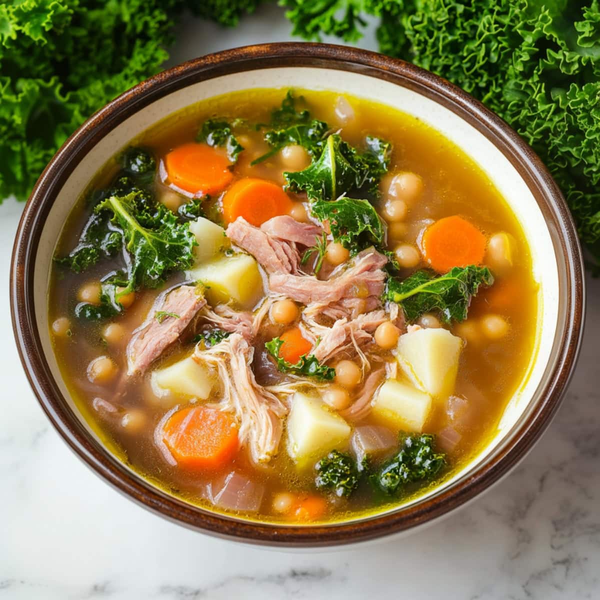 A bowl of scotch broth showcasing shredded lamb, split peas, barley and carrots.