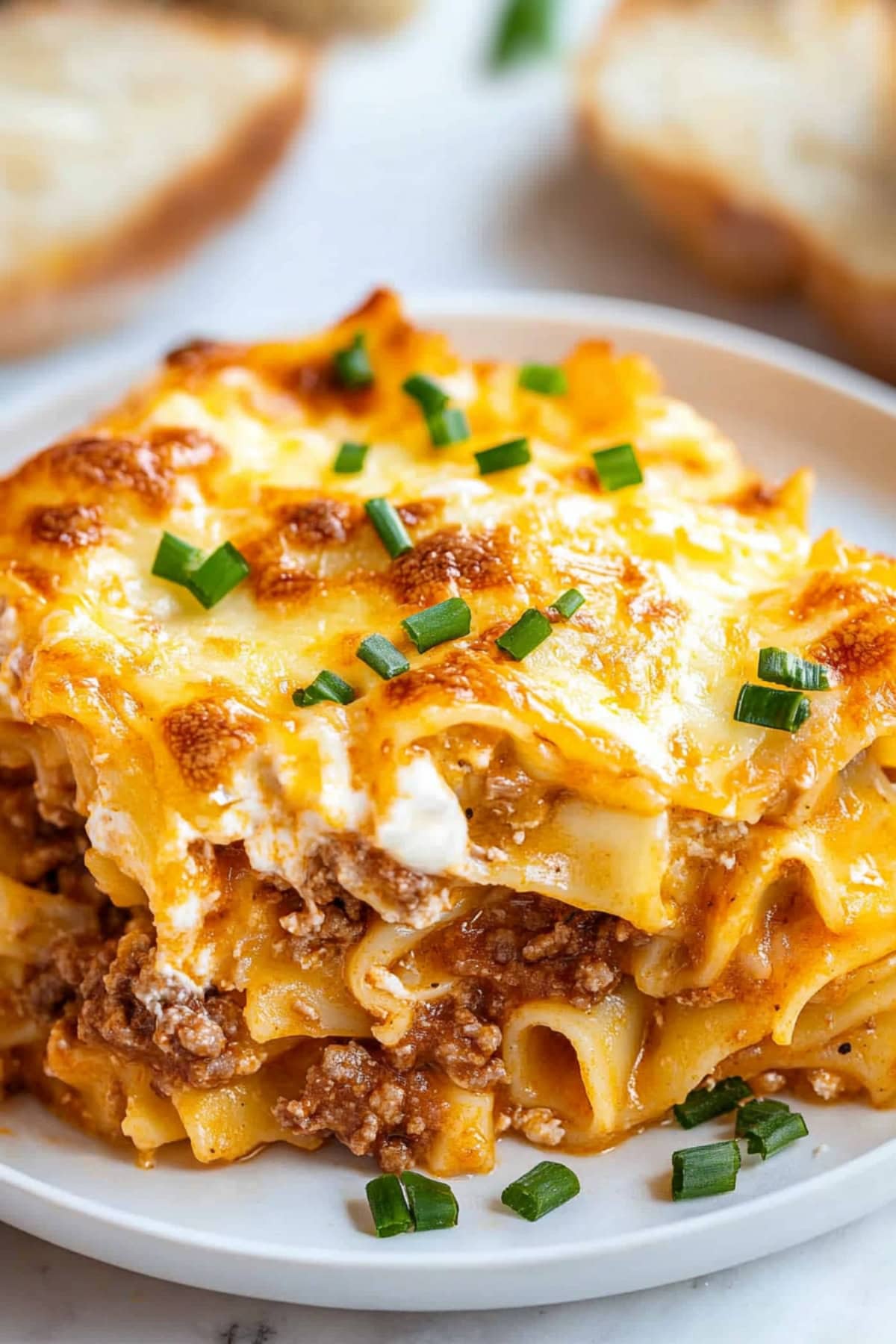 A close-up shot of sour cream noodle bake topped with chopped green onions.