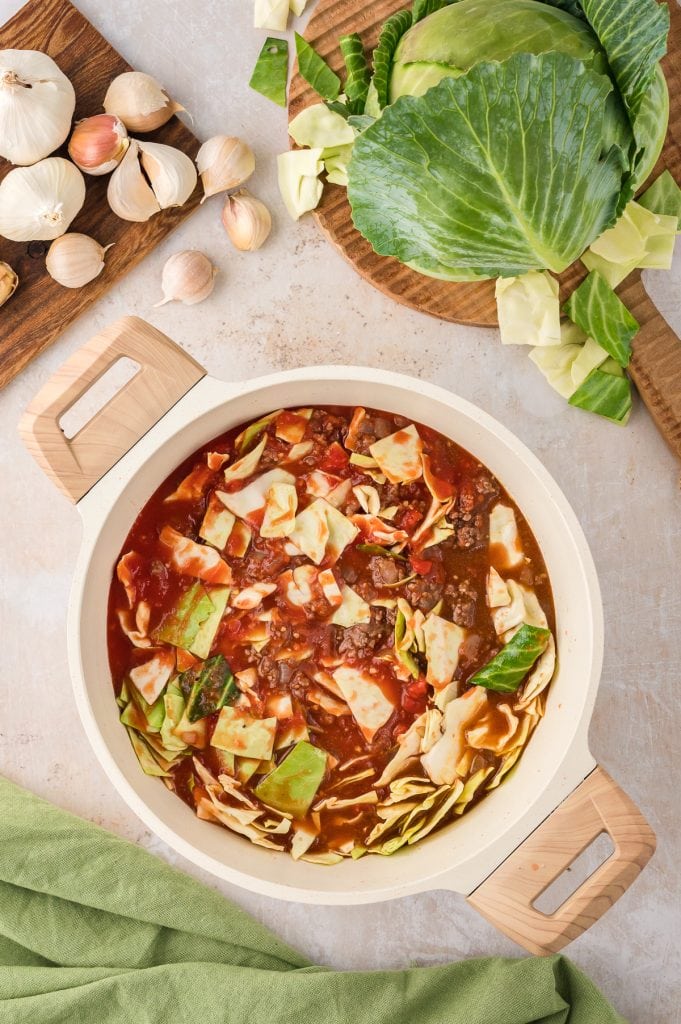 A mixture of ground beef, tomato sauce, and cabbage in a Dutch oven