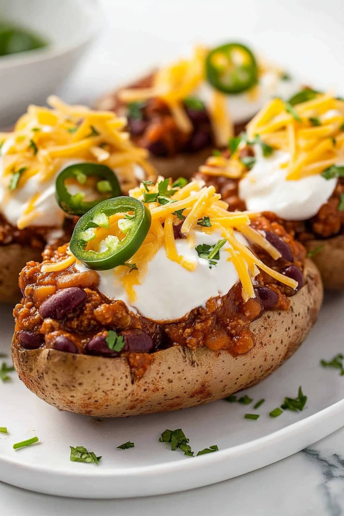 Homemade chili baked potatoes with ground beef, kidney beans, jalapenos, sour cream and shredded cheese. 