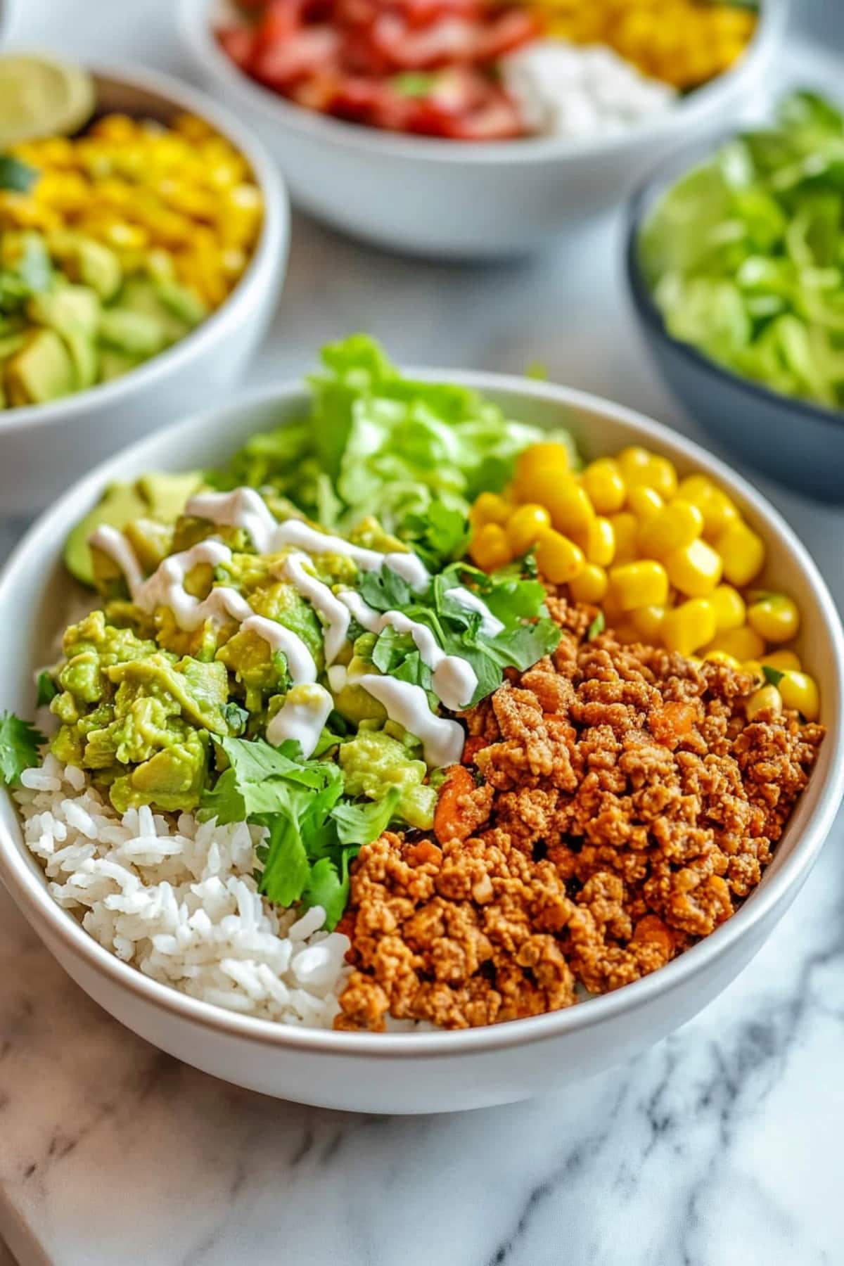 Chipotle Sofritas: Cooked tofu, corn, guacamole, lettuce and rice in a bowl.