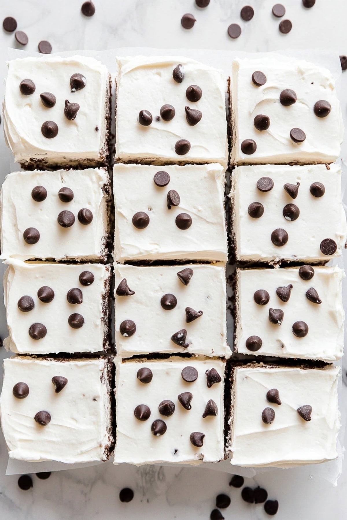 Chocolate chip sheet cake with white frosting and chocolate chips on top, top view