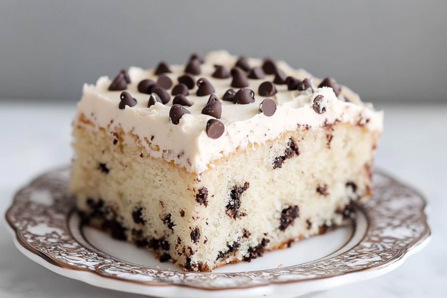 Slice of chocolate chip sheet cake on a saucer.