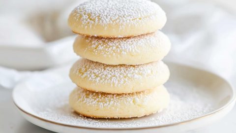 Pieces of cream cheese cookies sitting on top of each other in a plate.