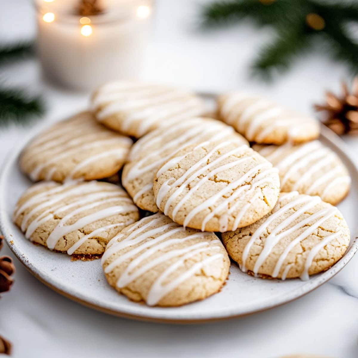 Soft eggnog snickerdoodle cookies with a drizzle of sweet glaze on a plate