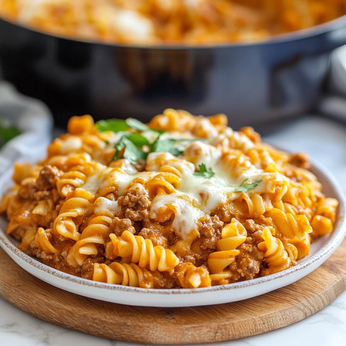 Cheesy and creamy enchiladas pasta served in a white plate.