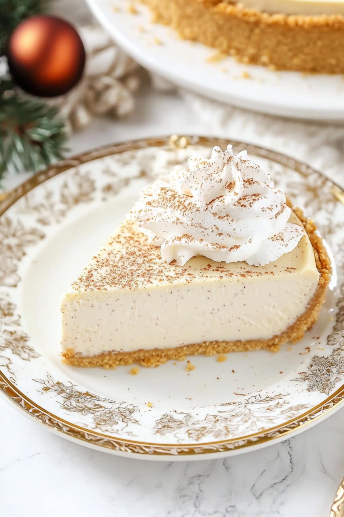 Homemade slice of eggnog cheesecake with graham cracker crust on an elegant plate.