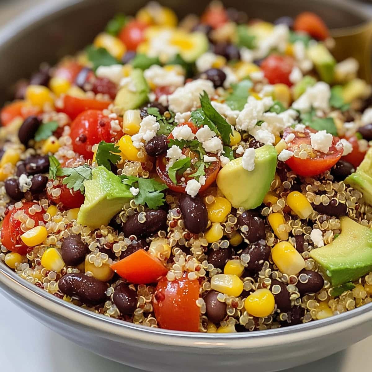 Homemade Southwest quinoa salad with avocado, black beans, tomatoes, chopped cilantro and crumbled cheese.