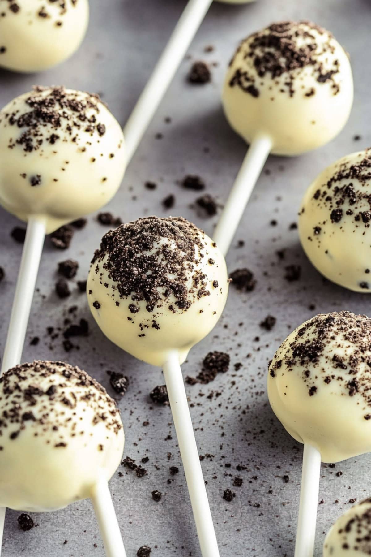 Oreo cake pops on stick dusted with crushed Oreo cookies.