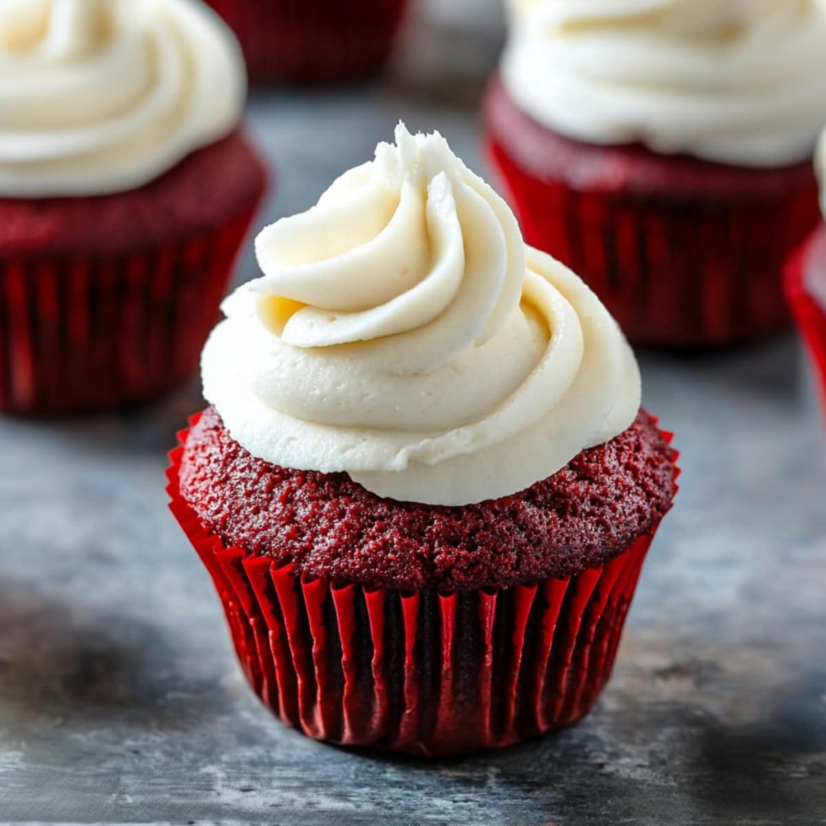 Close-up of a moist red velvet cupcake topped with cream cheese frosting.