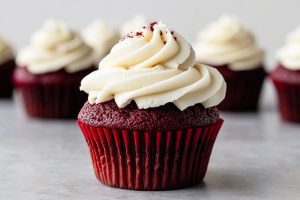 Homemade fluffy red velvet cupcakes topped with cream cheese frosting.