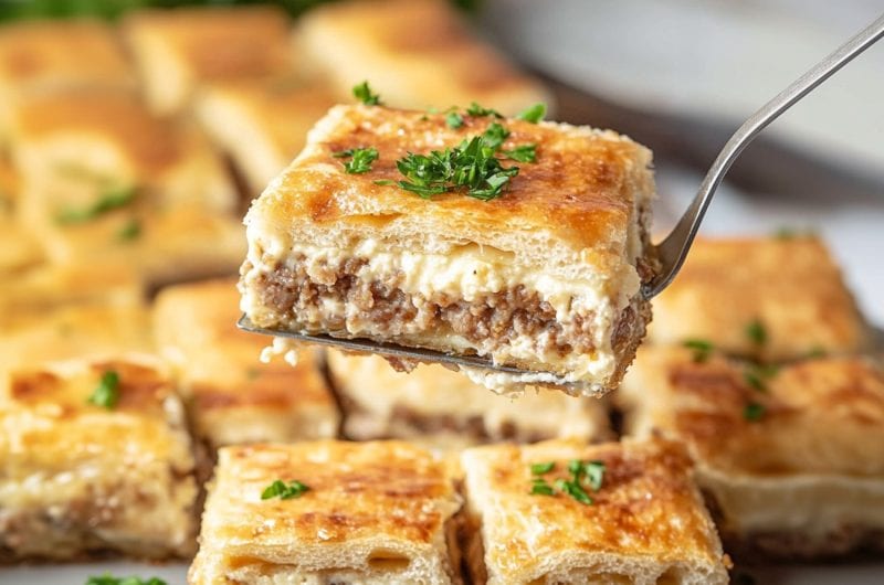 Pie ladle lifting a square slice of sausage cream cheese.