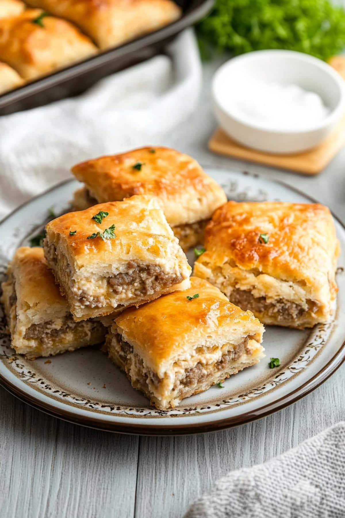 Sausage cream cheese casserole sliced in squares served in a white plate. 