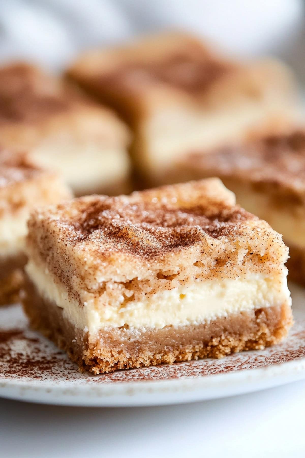 Snickerdoodle bar with cheesecake filling served on a white plate. 